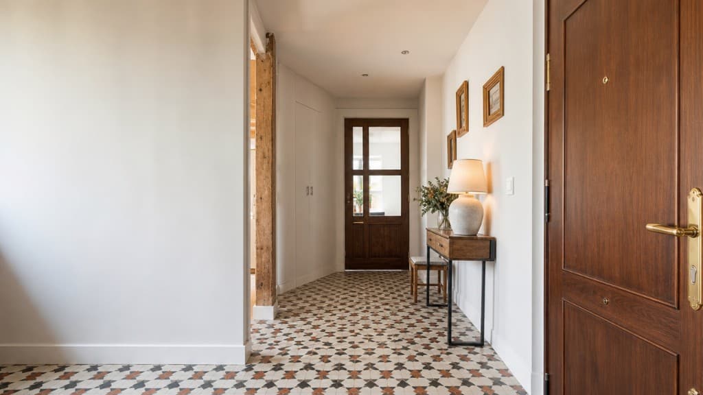 Entrada y recibidor de piso reformado con consola, espejo y madera